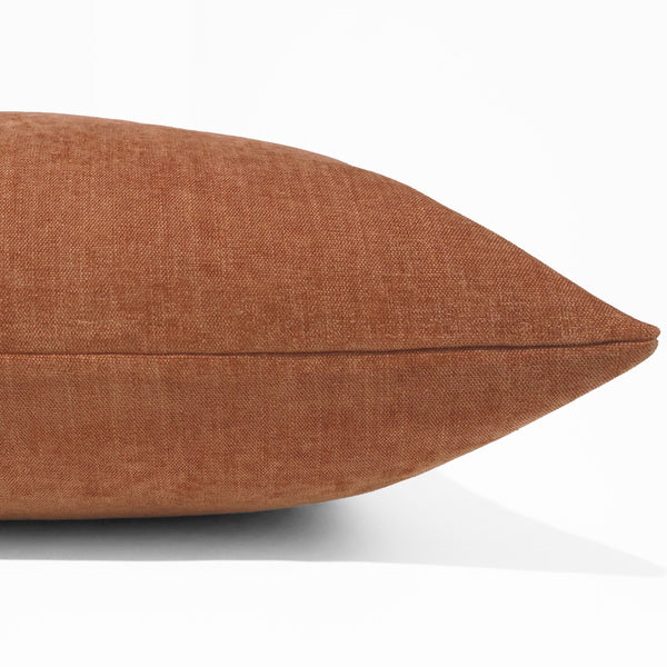 Rust velvet pillow cover with soft woven texture, front corner detail