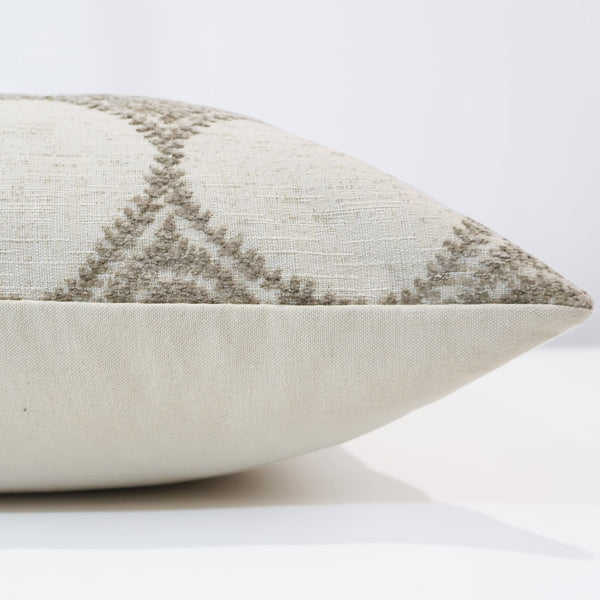 Ivory trellis pillow cover with embroidered taupe lattice pattern, front corner detail