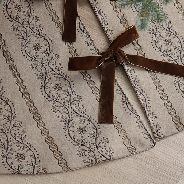 Vintage botanical Christmas tree skirt handmade from warm natural designer fabric with brown floral stripes and velvet ribbon ties under a Christmas tree