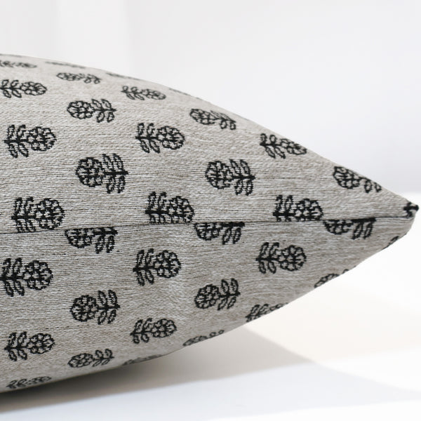 Gray pillow with black leaf pattern on a white background