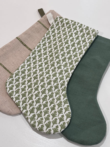 Full view of all three stockings in the Boho Stocking Set, showing the matching flax linen and green color palette.