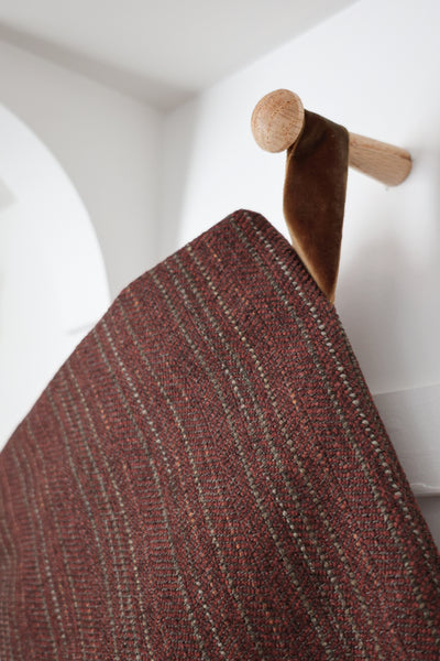Close-up of deep berry red woven Christmas stocking showing subtle textured stripes and velvet hanging loop.