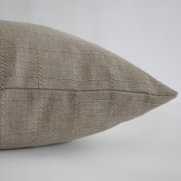 Close-up side view of Hackner Home Belgian Countryside pillow cover in textured taupe linen with subtle grid weave pattern.