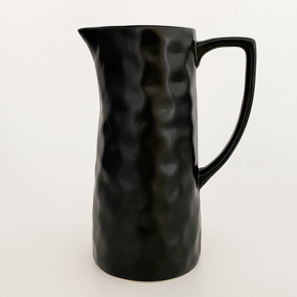 Hackner Home black ceramic serving pitcher with a hand-formed texture and matte finish shown against a white background.