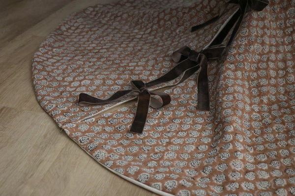 Brick rose block print tree skirt by Hackner Home – handcrafted fabric with velvet ribbon ties in a floral motif.