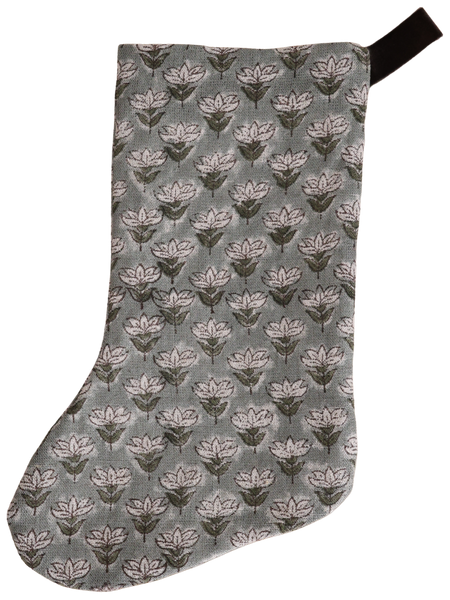 Muted blue floral block print Christmas stocking with hand-stamped design and dark velvet hanging loop, featuring a soft linen texture and boho-inspired pattern.