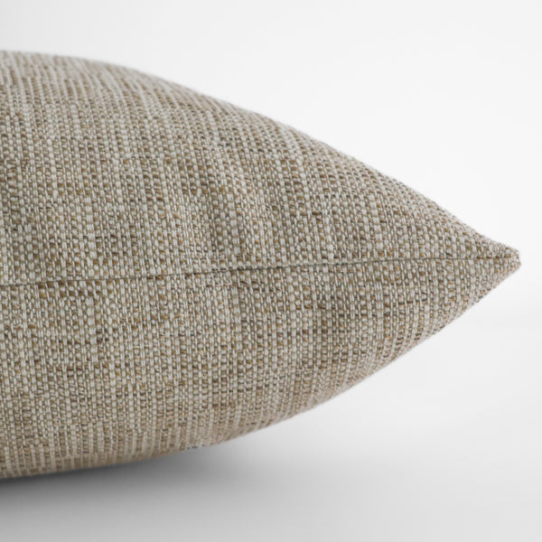 Close-up side view of Hackner Home Sand Petal outdoor pillow cover showcasing woven neutral beige fabric texture and fine stitching detail.