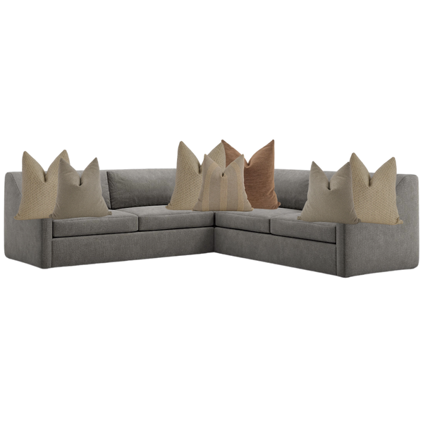 Modern brown sectional sofa styled with neutral throw pillows in beige, taupe, and clay tones — cozy living room corner seating.