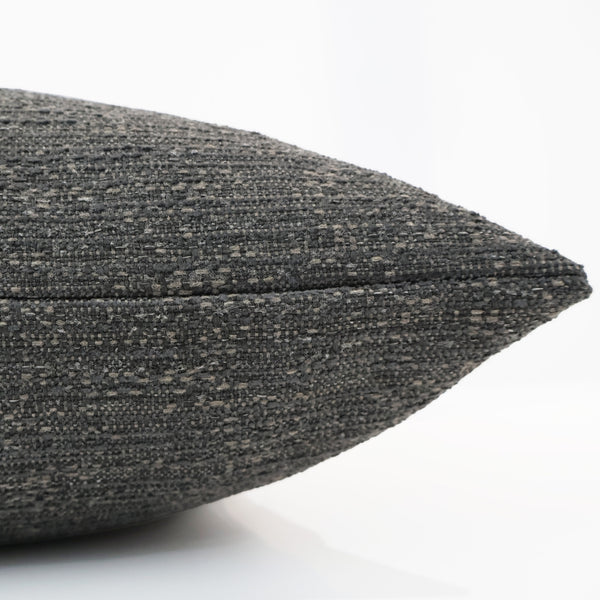 Side view of Hackner Home Smoked Umber pillow cover showing its textured charcoal-brown woven fabric and neatly finished seam.